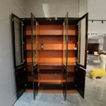 Dark Wood Wine Cabinet with Glass Display Doors, Warm Orange Interior and Stainless Steel Accents